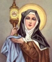 Devotional holy card of Saint Clare of Assisi in a brown Franciscan habit and dark veil, holding a monstrance with the IHS monogram.