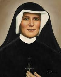 Color portrait photograph of Saint Faustina Kowalska in black habit and white veil, holding a small crucifix.