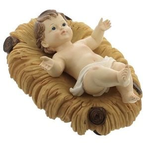 A ceramic or resin figurine of the Infant Jesus lying in a straw manger, one hand raised.